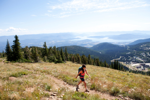 A woman hiking up Mt. Schweitzer while overlooking Sandpoint  Idaho and  Lake Pend Orielle.