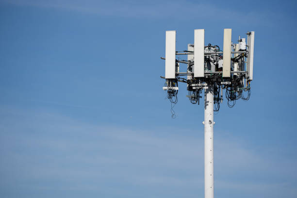 torre del cellulare nella città urbana isolata nel cielo blu - telephone network control room foto e immagini stock
