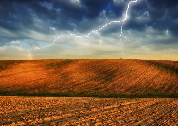 lightning over a hilly field. landscape with dramatic thunderclouds in the background