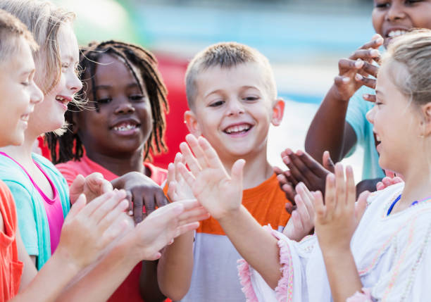 istock Group of children at water park, playing clapping game 1297509731