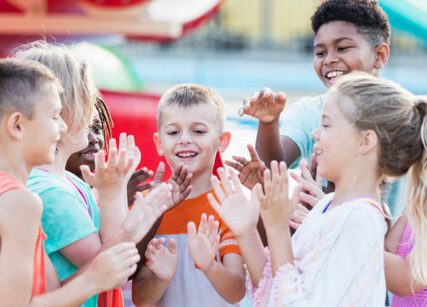 istock Group of children at water park, playing clapping game 1297509752