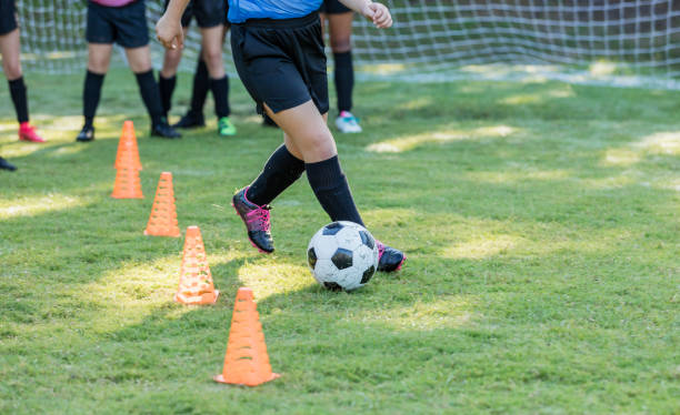 istock Girl's soccer team doing practice drills 1297510366