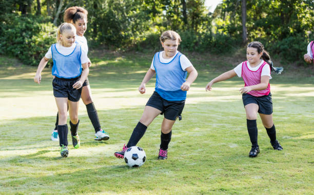 istock Girl's soccer team practicing, playing scrimmage 1297510373