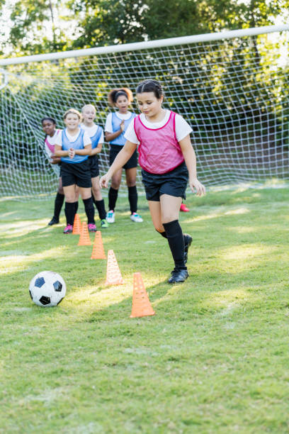 istock Girl's soccer team doing practice drills 1297510386
