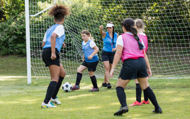 istock Girl's soccer team practicing, playing scrimmage 1297510395