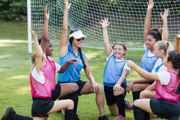 entrenador con chicas equipo de fútbol en acurrucarse, animando - soccer child coach childhood fotografías e imágenes de stock