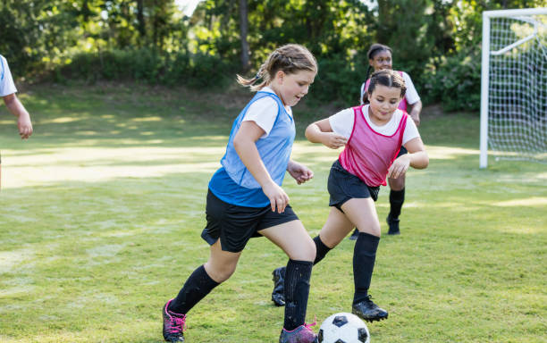 istock Girl's soccer team practicing, playing scrimmage 1297510431