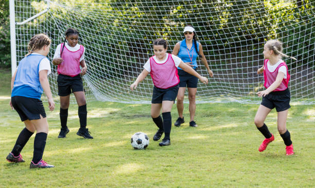 istock Girl's soccer team practicing, playing scrimmage 1297510466
