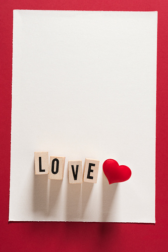 Love text on wooden cubes and Heart shape on White background. Horizontal composition with copy space. Love and Valentine's Day concept.