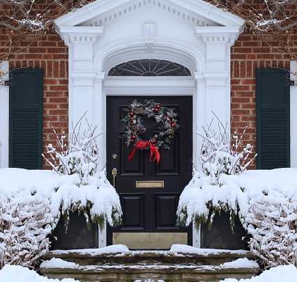 Front door of traditional home with Christmas wreath
