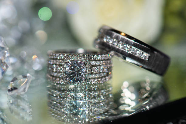 istock Blingy white gold wedding rings with diamonds on glass reflective surface 1297522243
