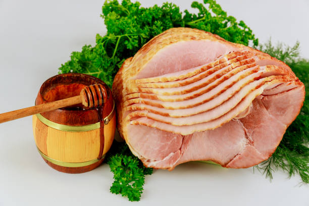 istock Spiral sliced hickory smoked ham with fresh herb and honey. 1297524051