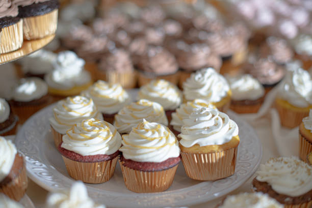 istock Vanilla cupcakes with vanilla frosting and caramel swirl on dessert table 1297524155