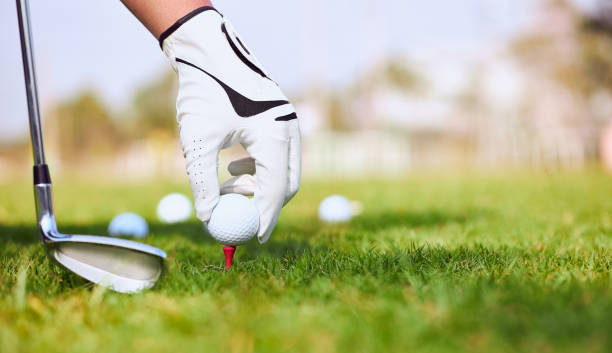 golfer hand setzen einen golfball auf abschlag in golfplatz. - golf course fotos stock-fotos und bilder