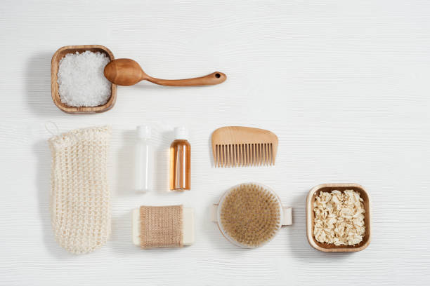 istock Flat lay composition with bath accessories with small bottles with gel and shampoo, soap, sea salt, washcloth on table with copy space. 1297528233
