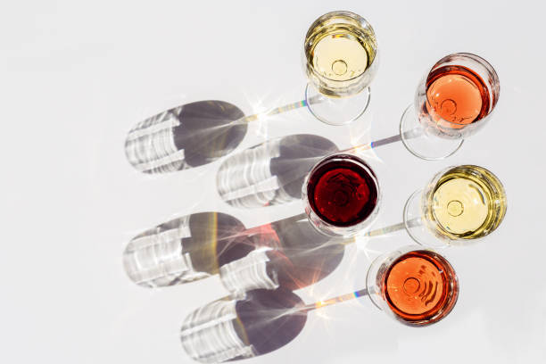 istock Red, rose and white wine top view in sunlight. Assorted wine in glass on white table. Dark shadows. 1297528256