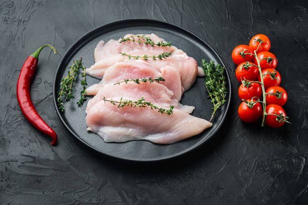 istock Raw chicken cutlet breast fillets, on black background 1297529822
