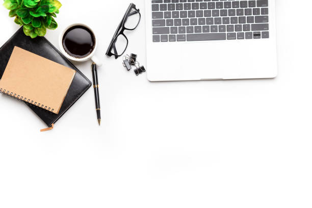 istock Flat lay, top view office table desk. Workspace with, laptop,office supplies, pencil, green leaf, and coffee cup on white background. 1297529985