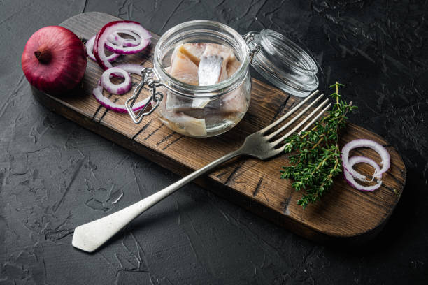 istock Sliced herring in oil, on black background 1297530656