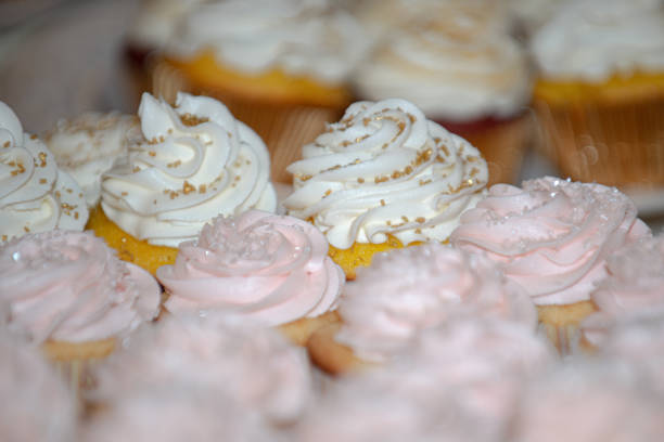 istock Vanilla cupcakes with vanilla frosting and gold sprinkles on dessert table 1297531675