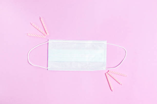 istock Quarantine face mask with candles for birthday cake on pink background 1297532920