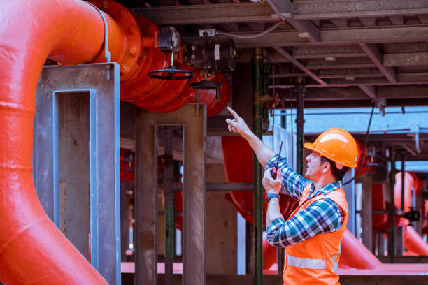 istock Engineer under checking the industry cooling tower air conditioner is water condenser cooling tower air chiller HVAC of large industrial building to control air system. 1297535511
