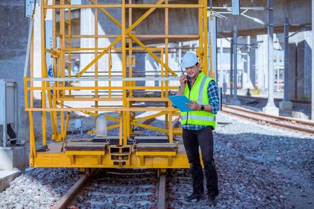 engineer railway under inspection and checking construction process train and railroad station .engineer wearing safety uniform and helmet by holding document in work. - switch yard imagens e fotografias de stock