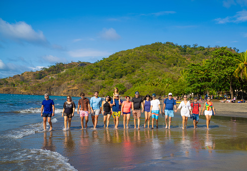 Big group of family and friends walking on a beach in Costa Rica