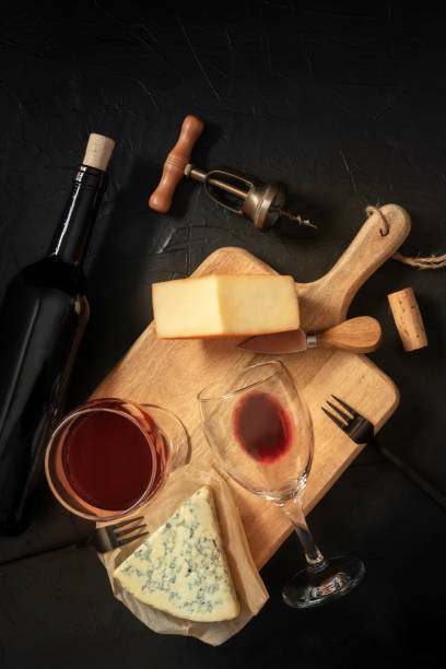 istock Wine and cheese tasting, shot from above on a black background, with a cork, corkscrew, and a bottle 1297540333