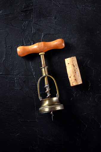 Wine cork and corkscrew on dark background