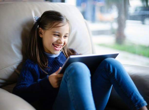 istock Child Girl Watching On Digital Tablet And Laughing 1297542510