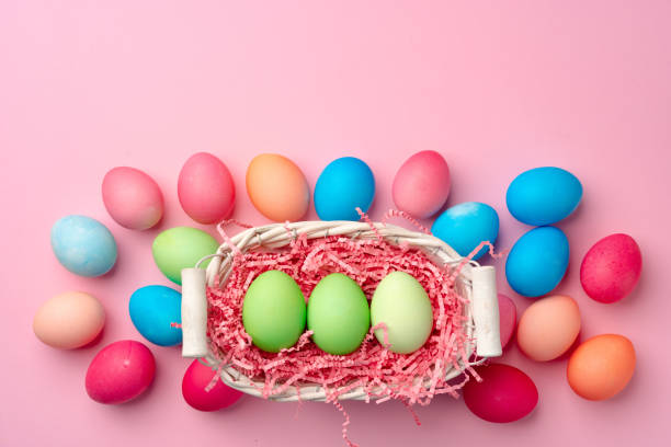 istock Painted Easter eggs in decorative nest on pink background 1297547503