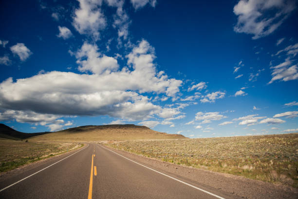 istock Open Road with Clouds and Sky in Background 1297547667