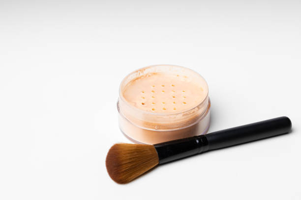 istock Decorative cosmetics face powder and brush close up 1297548086