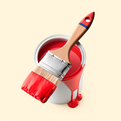 Paintbrush with red paint on a can isolated on yellow background.