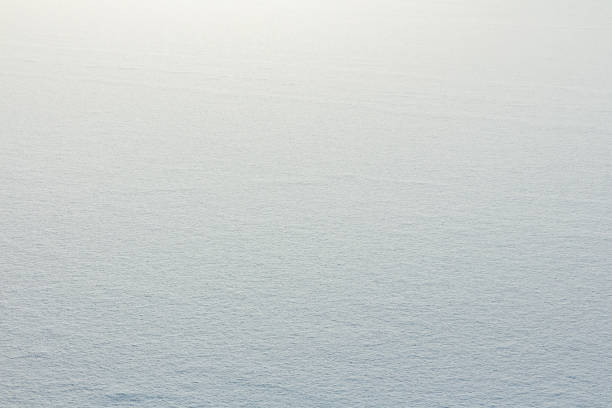 Snowy surface of a frozen lake. Natural winter background for design