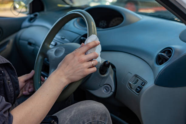 istock Hands wipes the steering wheel with an antibacterial cloth. Infection control concept. Prevent Coronavirus, COVID-19, flu. 1297551386