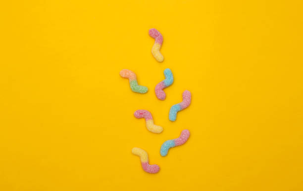 istock Gummy worms on a yellow background. Top view 1297552177