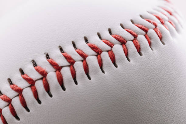 istock Close-up of a red thread seam on a white leather baseball 1297557591