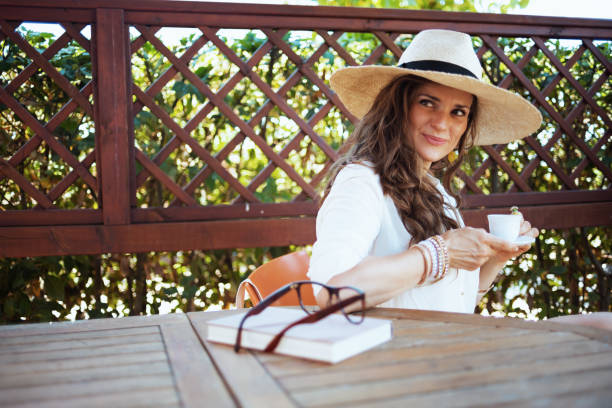 istock pensive elegant woman sitting at table drinking coffee 1297561842