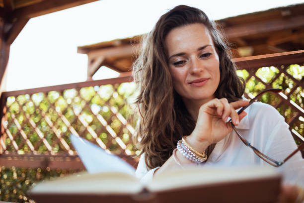 istock pensive modern woman in white shirt reading book 1297561957