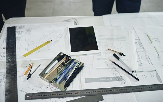 Shot of various tools and a blueprint on a table at a construction site