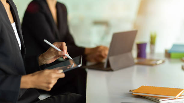 istock Businesswoman hands working with digital devices on meeting table 1297564166