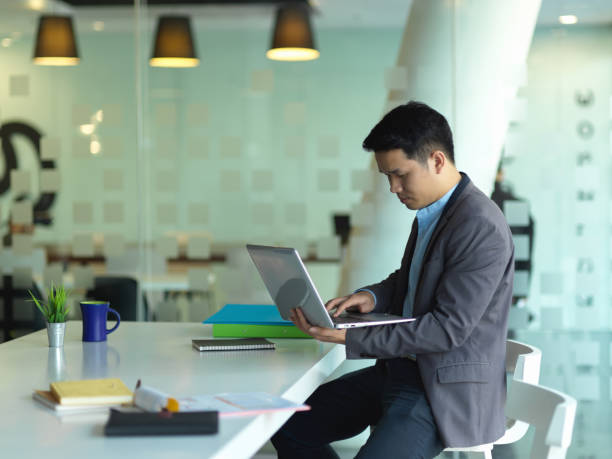 istock Male entrepreneur working with laptop computer while sitting in meeting room 1297564198