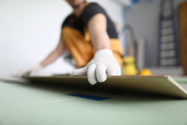 istock Professional craftsman lay laminate on floor on substrate in room. 1297565396