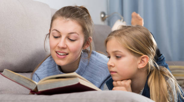 istock Mother and daughter reading at home 1297565481
