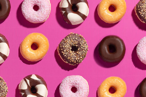 istock Flat lay composition of mixed donuts on pink background. 1297565859