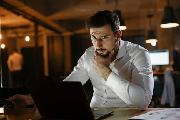 istock Businessman sitting at office desk working on laptop computer 1297566515