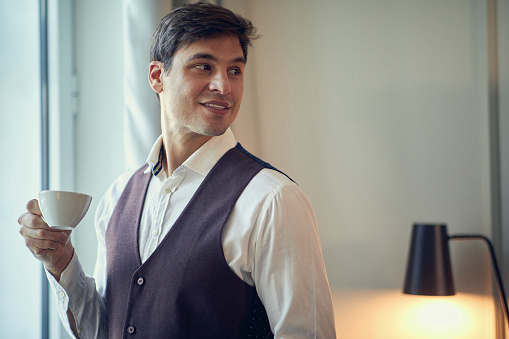 Young businessman preparing for a successfull day while drinking morning coffee