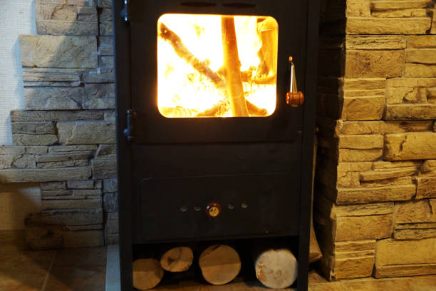 istock burning metal fireplace with wood at the stone wall 1297566948